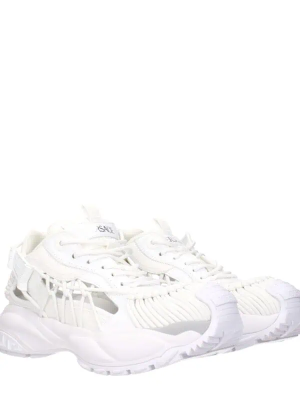 White luxury designer sneakers with intricate mesh and detailing, perfect for a stylish and comfortable look.