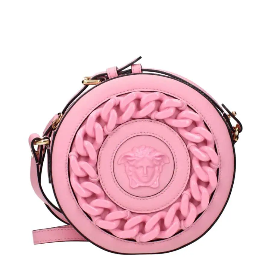 Pink round handbag with a prominent Medusa emblem and chunky chain detail, featuring a black strap and gold hardware, perfect for upscale fashion statements.