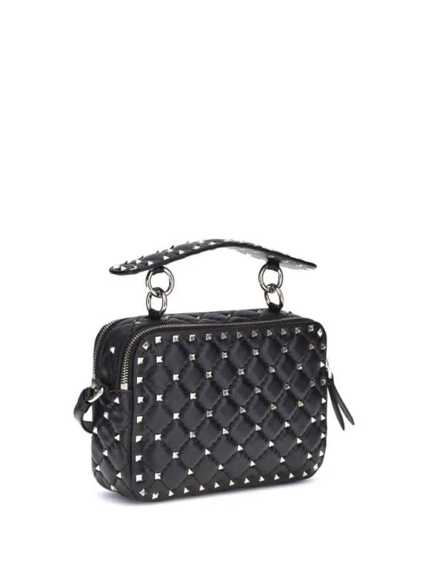 Crafted black quilted handbag with silver stud accents, top handle, and zipper closure, perfect for a stylish and edgy look.