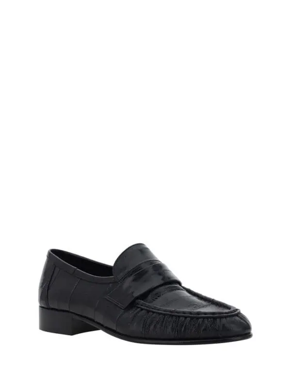 Black leather loafers with classic design, sleek stitching, and comfortable fit for formal and casual wear.