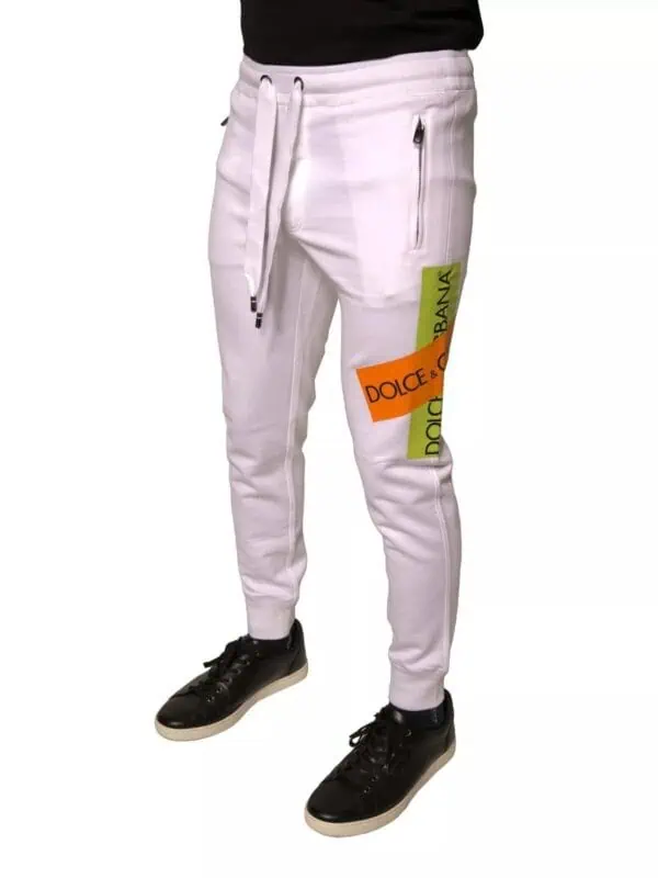 Luxury designer white Joggers with colorful Dolce & Gabbana logo patches, zipper pockets, and tapered fit for a stylish streetwear look.