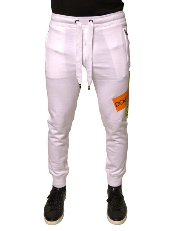 Dquad white sweatpants with colorful logo patch, drawstring waist, zippered pockets, and tapered ankle cuffs for a stylish, comfortable casual look.