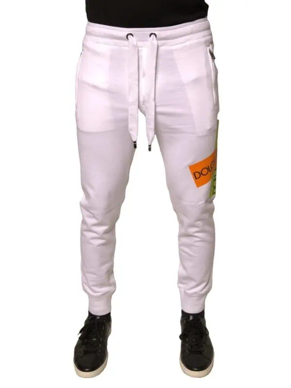 Dquad white sweatpants with colorful logo patch, drawstring waist, zippered pockets, and tapered ankle cuffs for a stylish, comfortable casual look.
