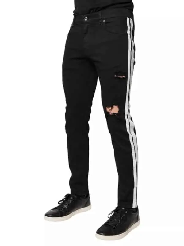 Distressed black jeans with white side stripes, ripped knees, and slim fit, paired with black sneakers, stylish urban streetwear for men or women from Lux Brands.